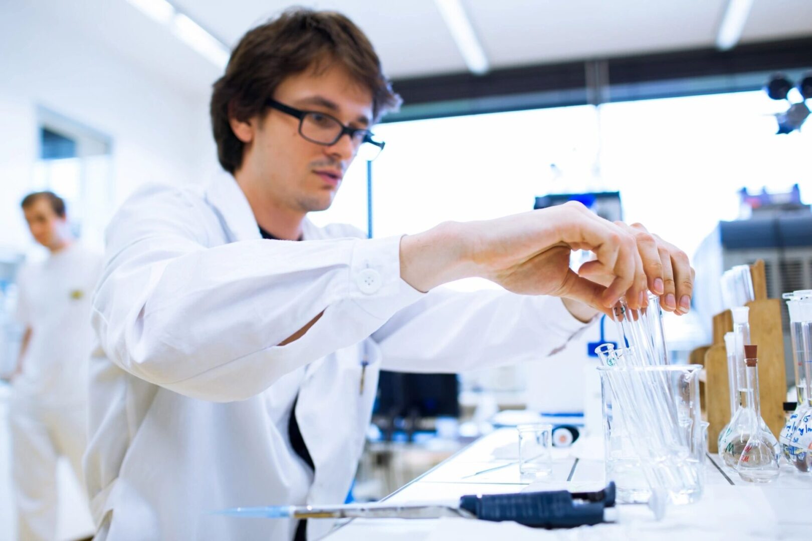 Scientist holding test tubes in lab.